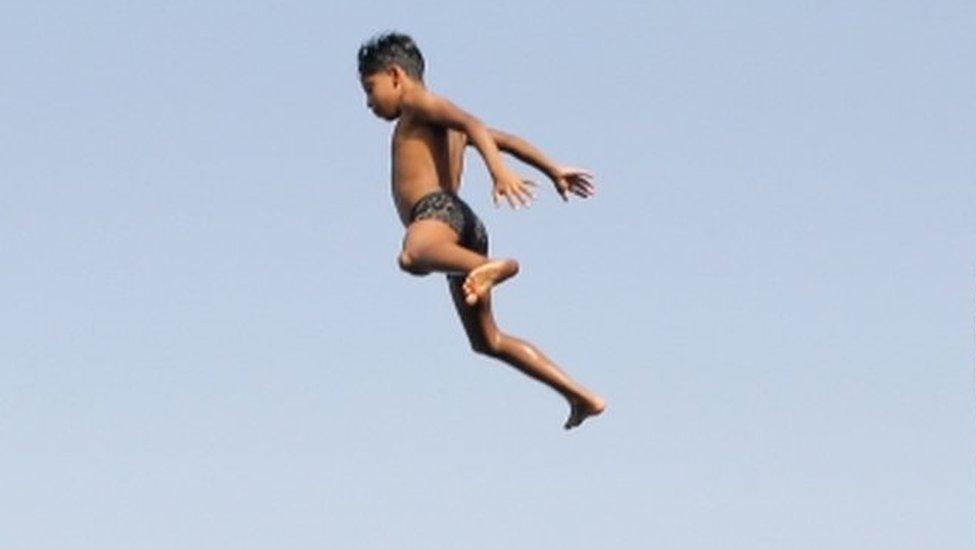 Children jump into the water of the Nile.