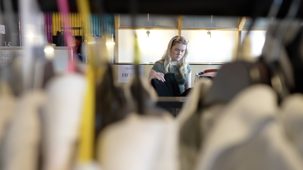 A lady browsing in the uniform exchange.