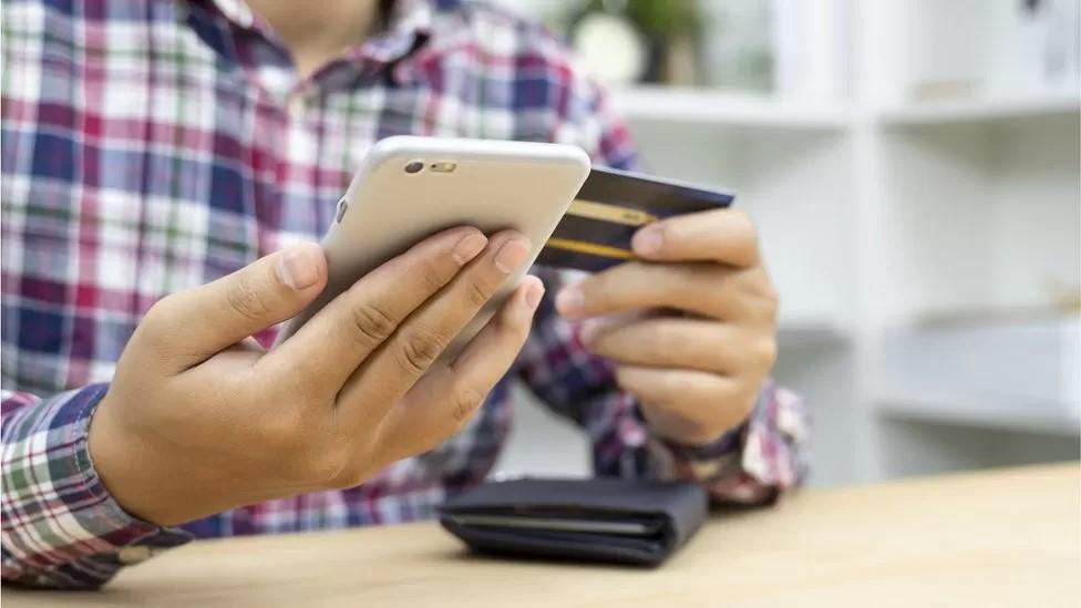 Man on mobile phone with credit card