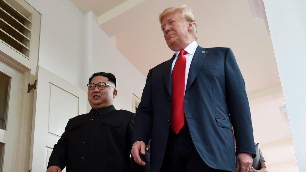 North Korea"s leader Kim Jong Un (L) walks with US President Donald Trump (R) at the start of their historic US-North Korea summit