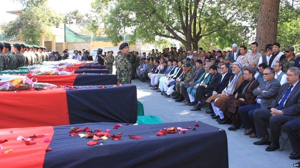 Afghan National Army (ANA) soldiers stand guard beside the flag-covered coffin of Afghan policemen killed in a battle with the Taliban in Kabul (06 July 2015)