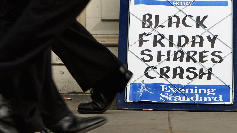 City workers pass the Evening Standard headline board showing the words 'Black Friday Shares Crash' during lunch time on Friday on October 10, 2008 in London