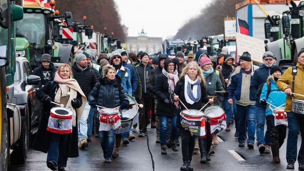 Demonstrators, leaving a rally, walk with drums in front of the Brandenburg Gate during a nationwide farmers' strike in Berlin, Germany, 15 January 2024