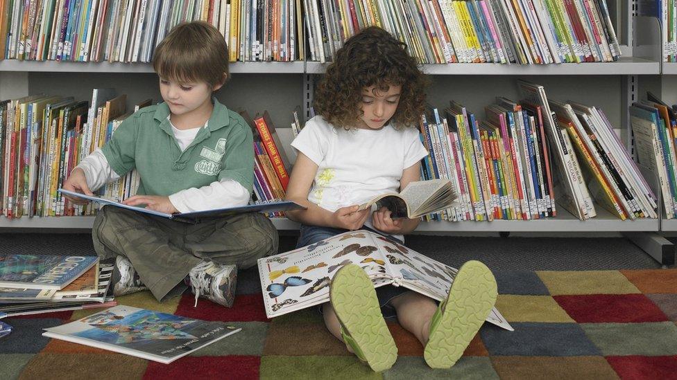 Two children sit and read