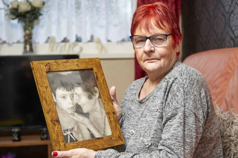 Gwynneth Hunter holding a photo of her daughter and herself together