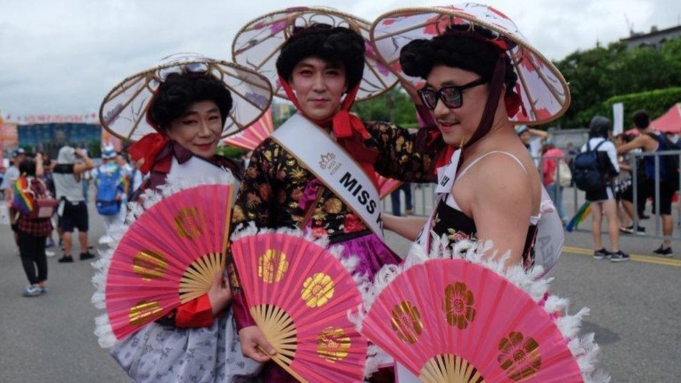 Three men in traditional Taiwanese female dress in Taipei on 29 October