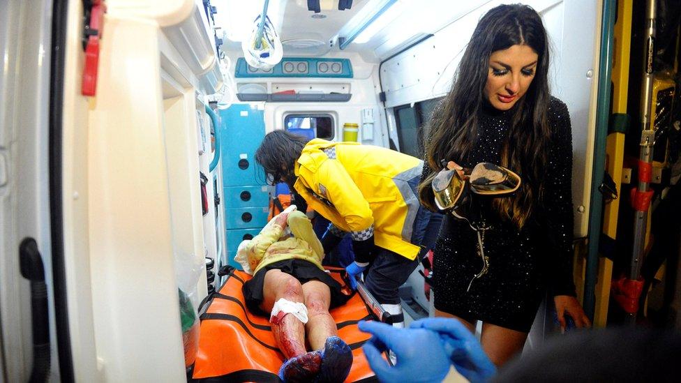 An injured woman is carried to an ambulance from a nightclub where a gun attack took place during a New Year party in Istanbul