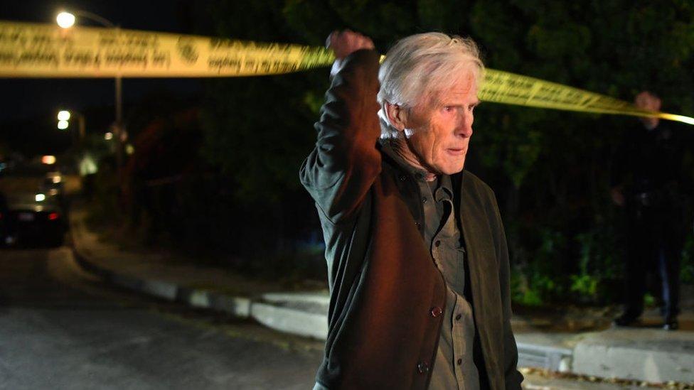 Keith Morrison crosses the police tape down the street from where Matthew Perry's house in Pacific Palisades