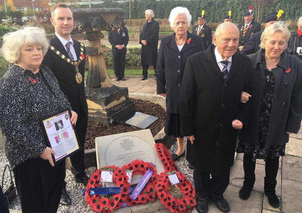 Family and mayor around paving stone