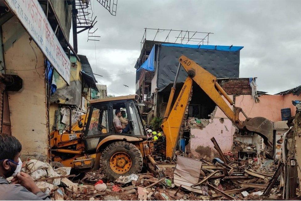 Rescue workers search for survivors in the debris after a residential building collapsed in Mumbai, India, June 10, 2021