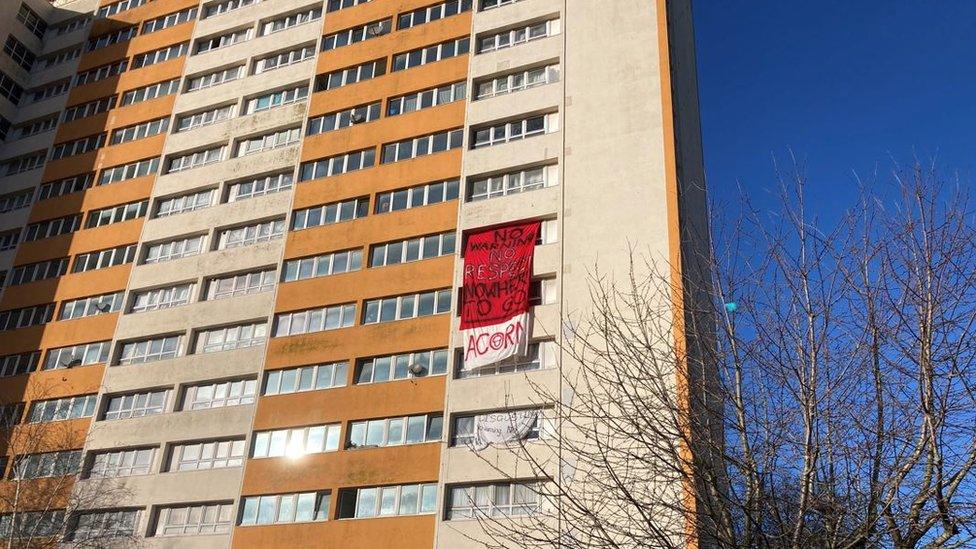 Barton House with a banner hanging out of a window which reads 'No warning, no respect, nowhere to go'