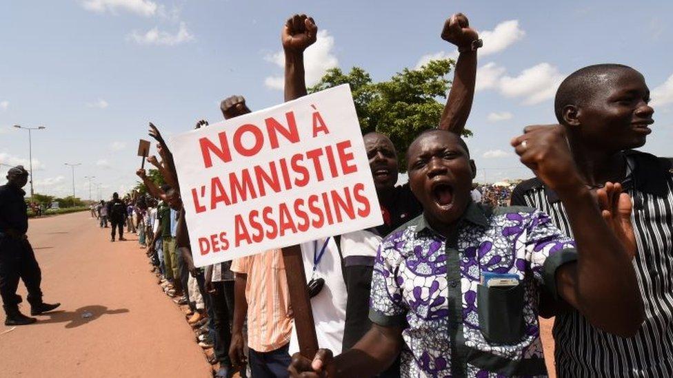 Protesters shout slogans while holding a sign reading "No to an amnesty for assassins" during a demonstration not far from the hotel where Ecowas leaders were holding a meeting in Ouagadougou on 23 September 2015