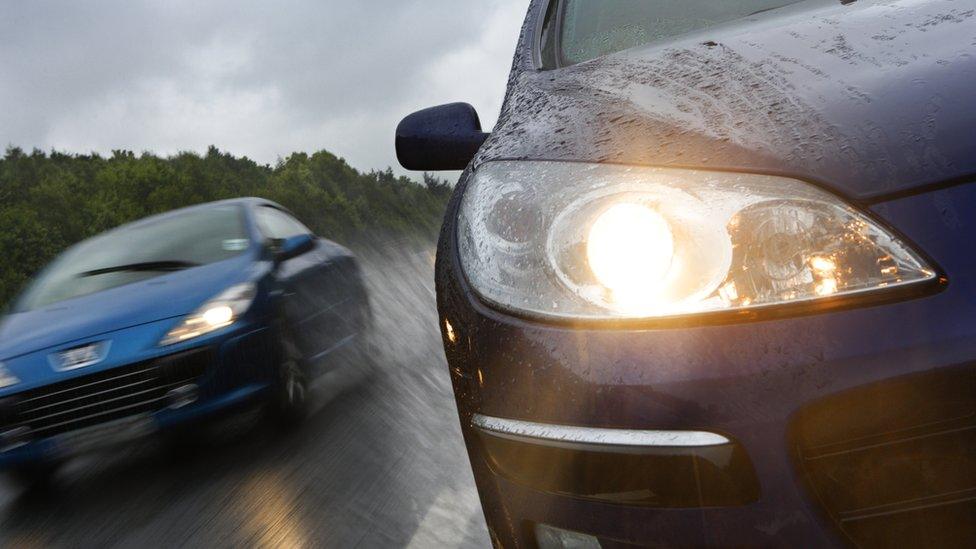 Car overtaking another in the rain