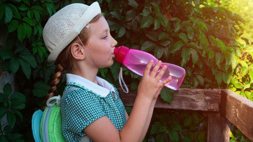 Girl drinks from water bottle