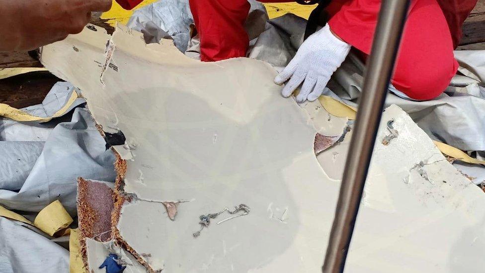 An official examines a piece of suspected plane debris