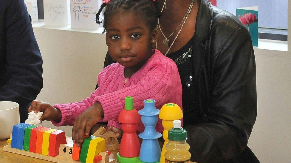 Child playing on parent's knee