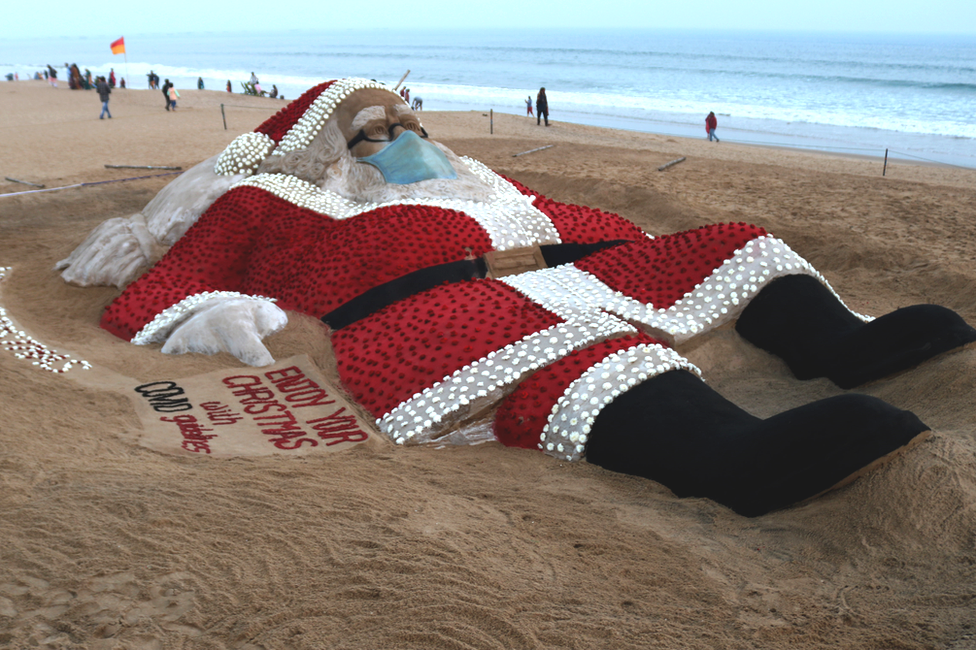 A giant sand sculpture of Santa Claus on the beach of Bay of Bengal in Odisha state, India. Photo: 24 December 2021