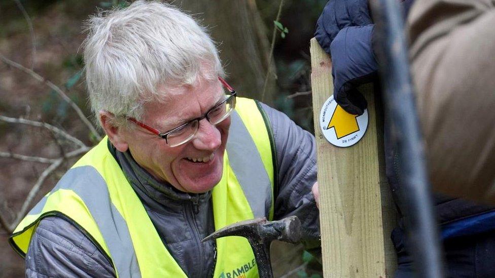 Volunteer fixing waymarker