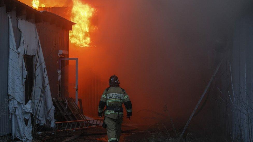 Firefighters put out a blaze at a toy shop after rockets hit downtown Donetsk