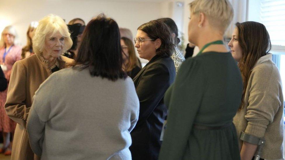 The Queen stands to the left while speaking to a small group of people