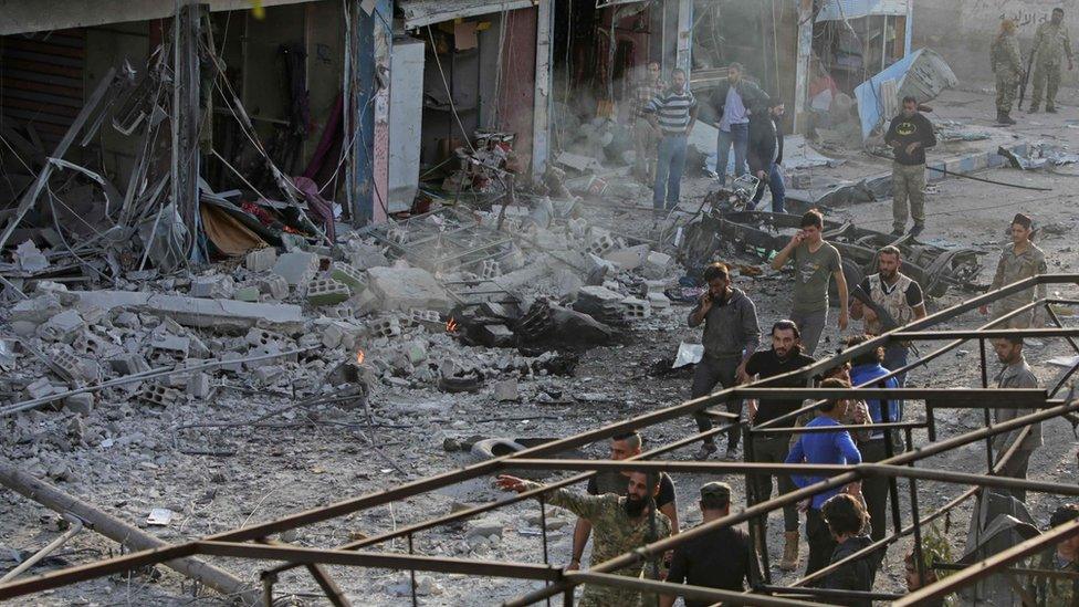 Turkey-backed Syrian fighters inspect the site of a car bomb explosion in the northern Syrian Kurdish town of Tal Abyad, on the border with Turkey, on November 2, 2019.