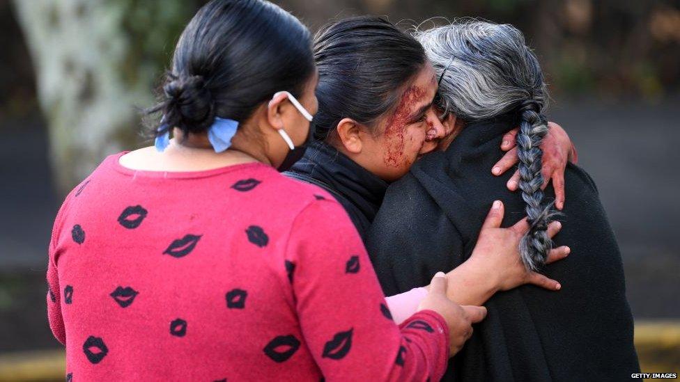 Bystanders mourn after witnessing the attack on Omar Garcia Harfuch, which killed three and injured Harfuch