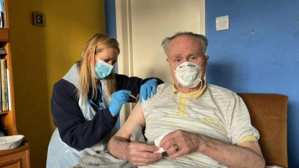 A housebound gentleman receives a vaccine jab in his front room