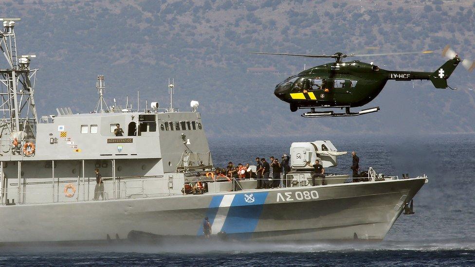 A Frontex helicopter and a Greek Coast guard vessel stop a dinghy with a suspected smuggler aboard off the Greek island of Lesbos