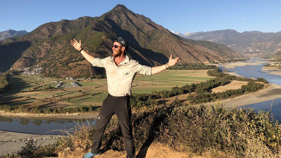 Ash Dykes standing in front of a mountain with the River Yangtze in the background