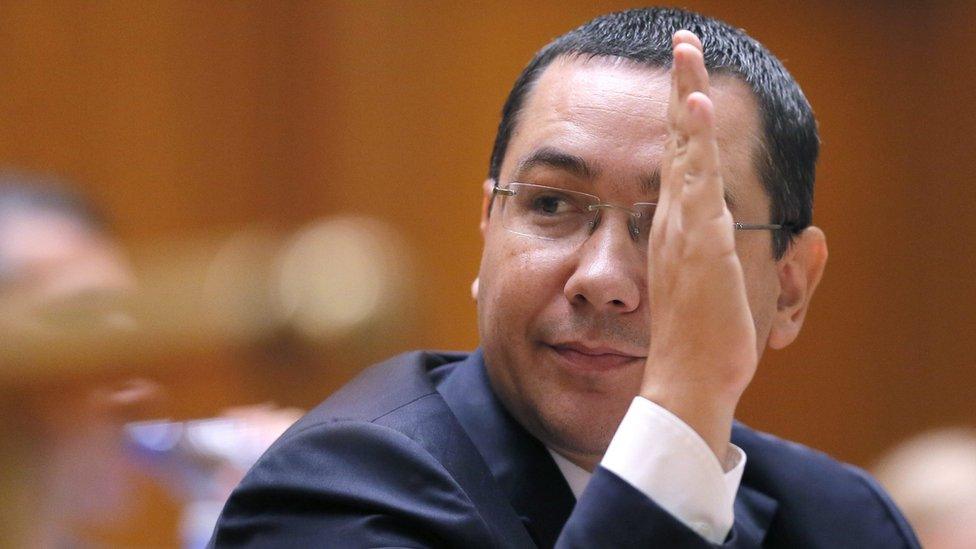 Romanian Prime Minister Victor Ponta raises his hand during a speech in front of both parliament chambers during no-confidence motion procedures