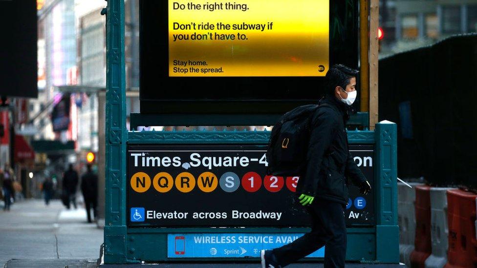 A man passes by a Times Square subway station 42nd street as New York City attempts to slow down the spread of coronavirus through social distancing on April 1, 2020