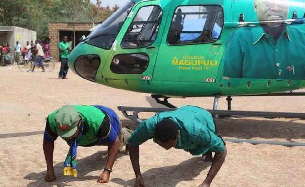 CCM politicians doing press-ups in front of a helicopter