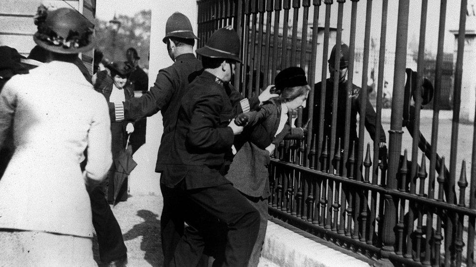 A Suffragette being arrested by police officers during a protest outside Buckingham Palace in 1914