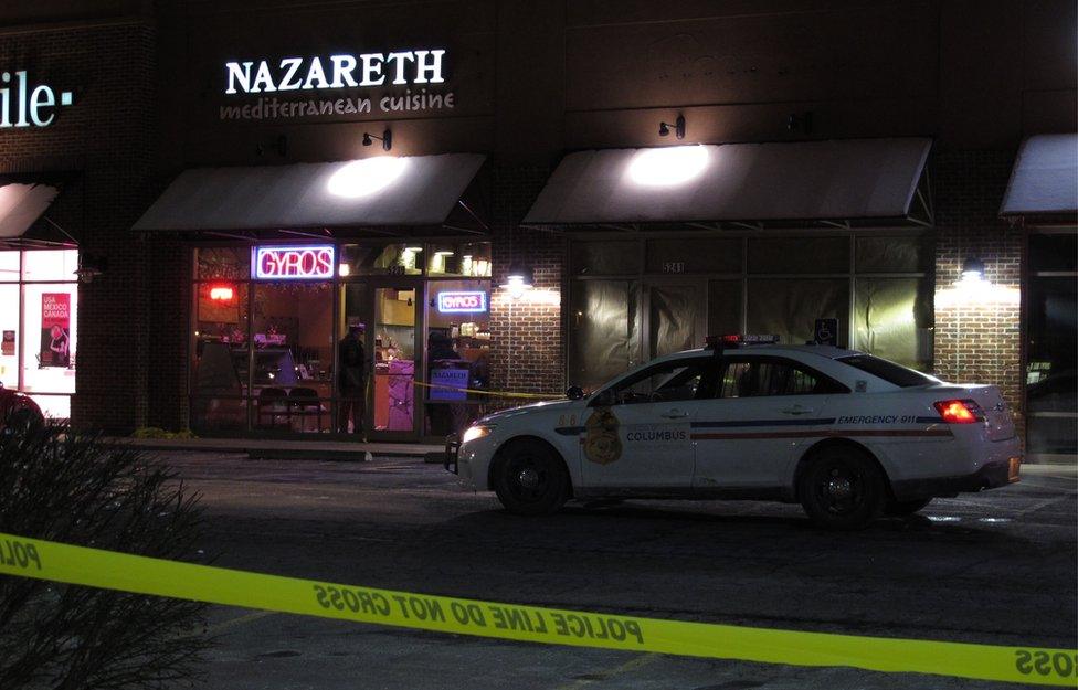 A police car parked outside the restaurant where the machete attack happened