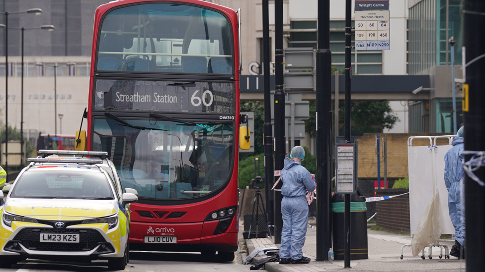 Bus and police car at the scene of the stabbing