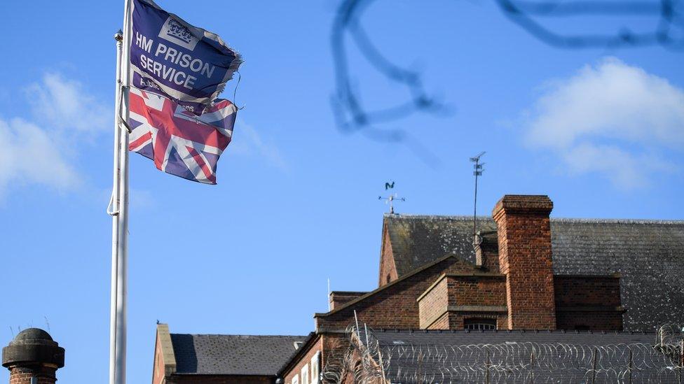 A union jack and a HM Prison service flag flying at a prison