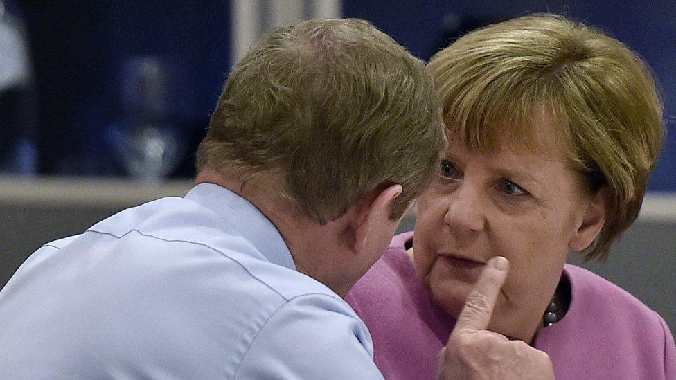 Irish Prime Minister Enda Kenny (L) speaks with , German Chancellor Angela Merkel (R) as they attend a European Union (EU) heads of state dinner during an EU summit in Brussels on February 19, 2016.