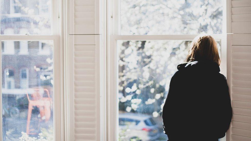 Woman staring out of a window