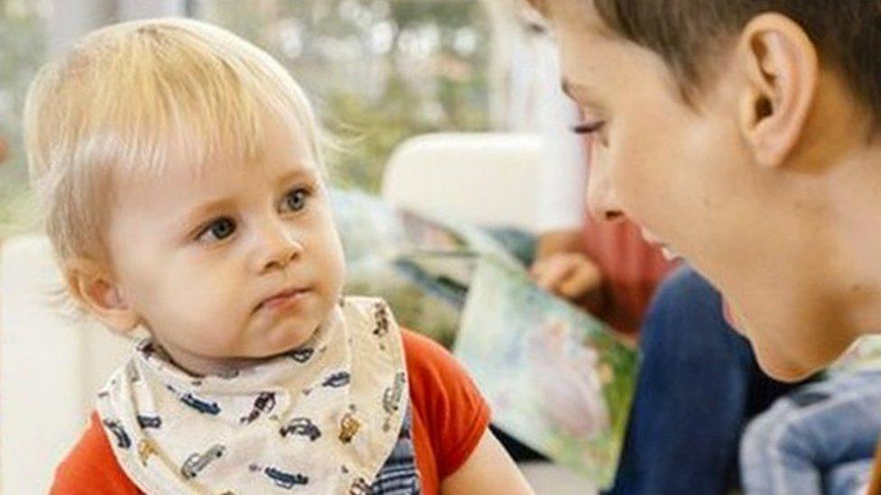 A pre-school teacher playing with a little boy