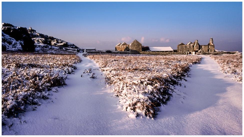 Eira dros yr ynys ac adfail yr hen fferm