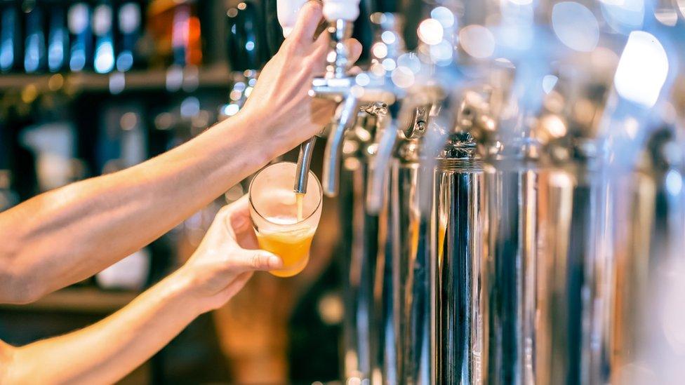 A bartender pouring a pint of beer