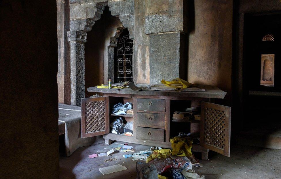 A dresser with papers strewn about