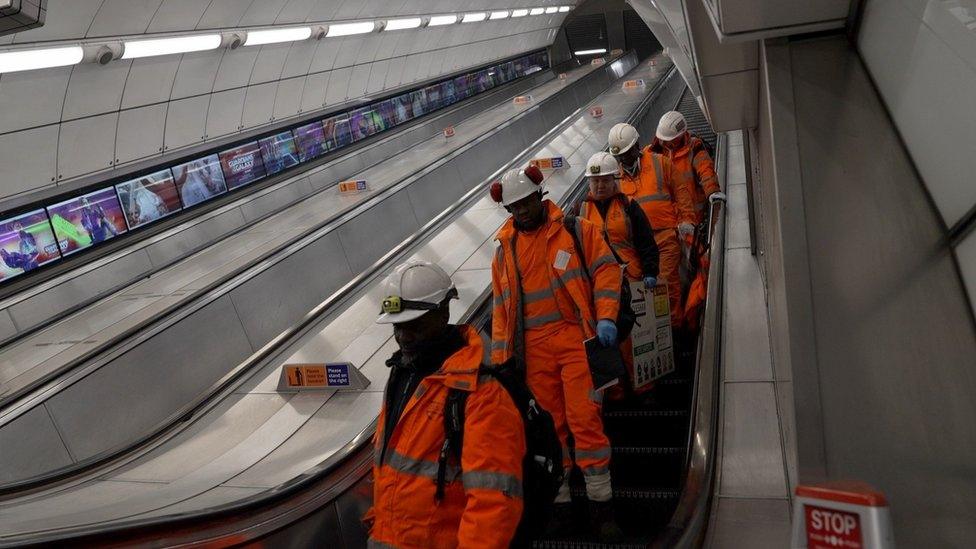 Tube fluffers head down an escalator to clean Underground