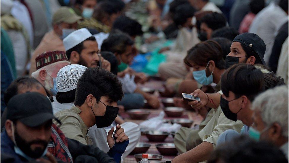 Muslim devotees break their Iftar fast along a road during the Holy month of Ramadan in Rawalpindi on April 28, 2021.