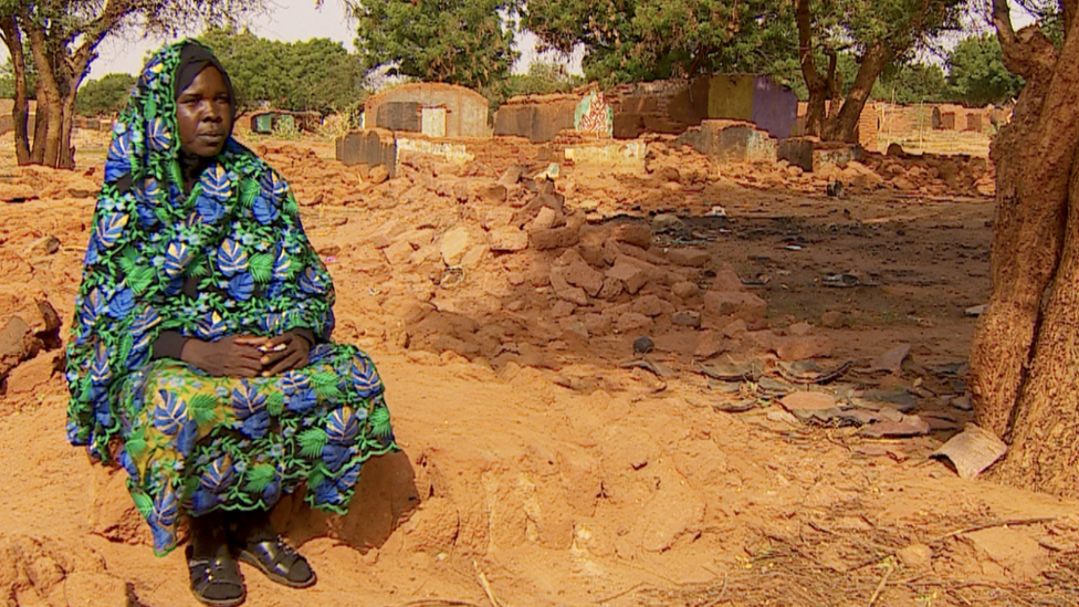 Khamisa Juma Ishag Abaker sits on the rubble of her home in West Dafur