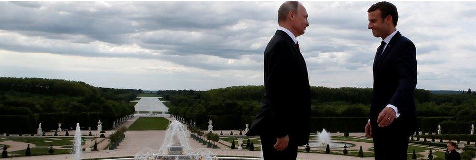 French President Emmanuel Macron (R) and Russian President Vladimir Putin pose in the gardens of the Versailles Palace following their meeting in Versailles, near Paris, France, May 29