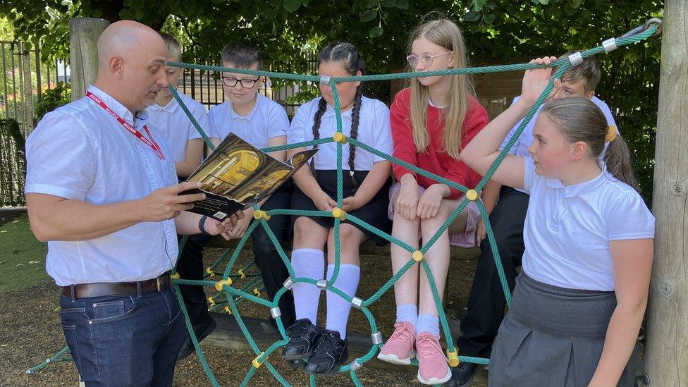 Carl Heslop reading to pupils