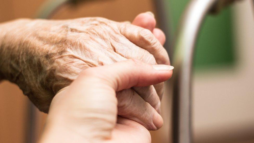 Holding older persons hand