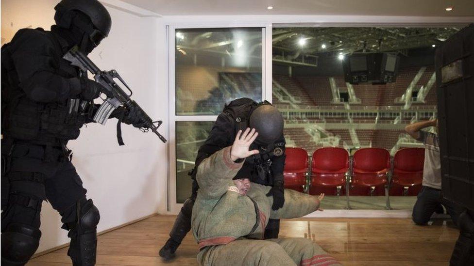 Police officers handle a man during a security drill at the Rio Olympic Arena in Rio de Janeiro, Brazil, Tuesday, April 12, 2016