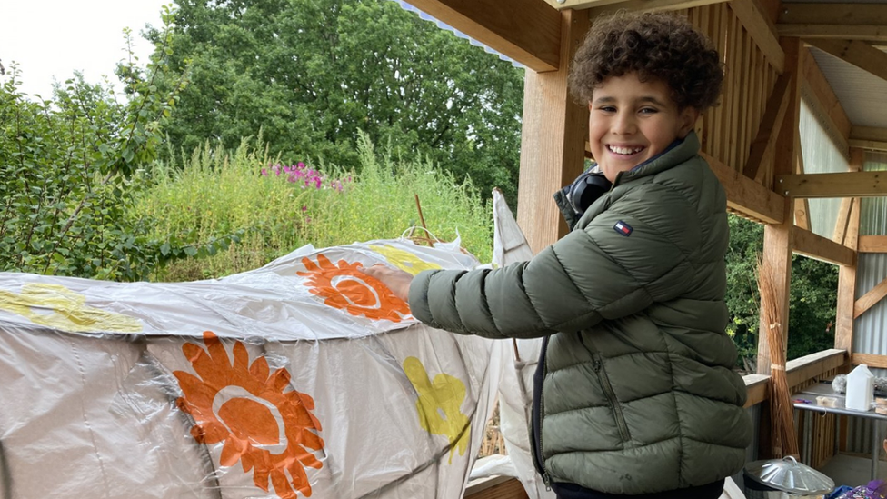 A boy decorating a fox lantern